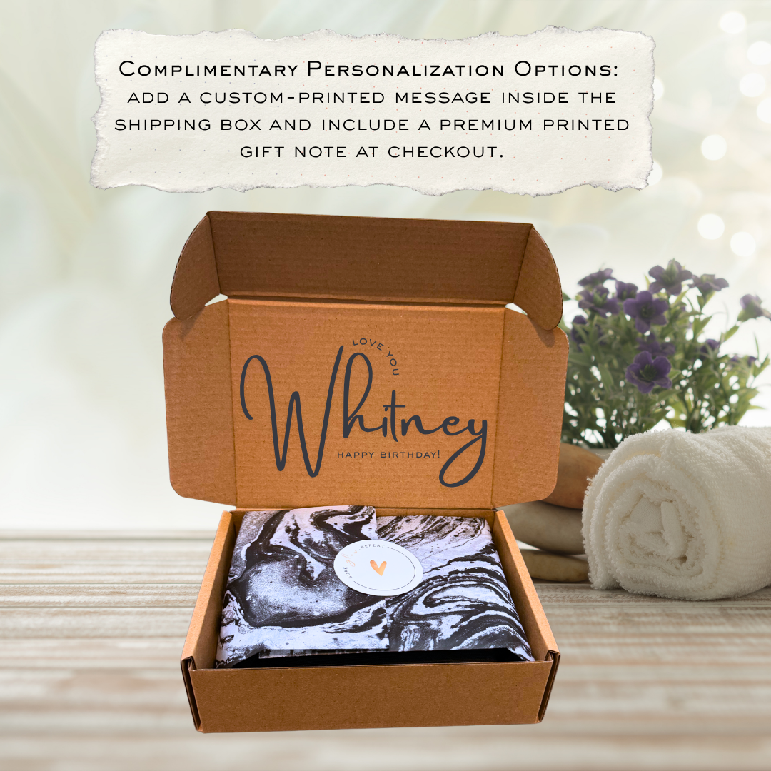 An open Partake Bodycare cardboard shipping box displaying a custom-printed script name message on the inner lid, filled with marbled tissue paper package wrapping.